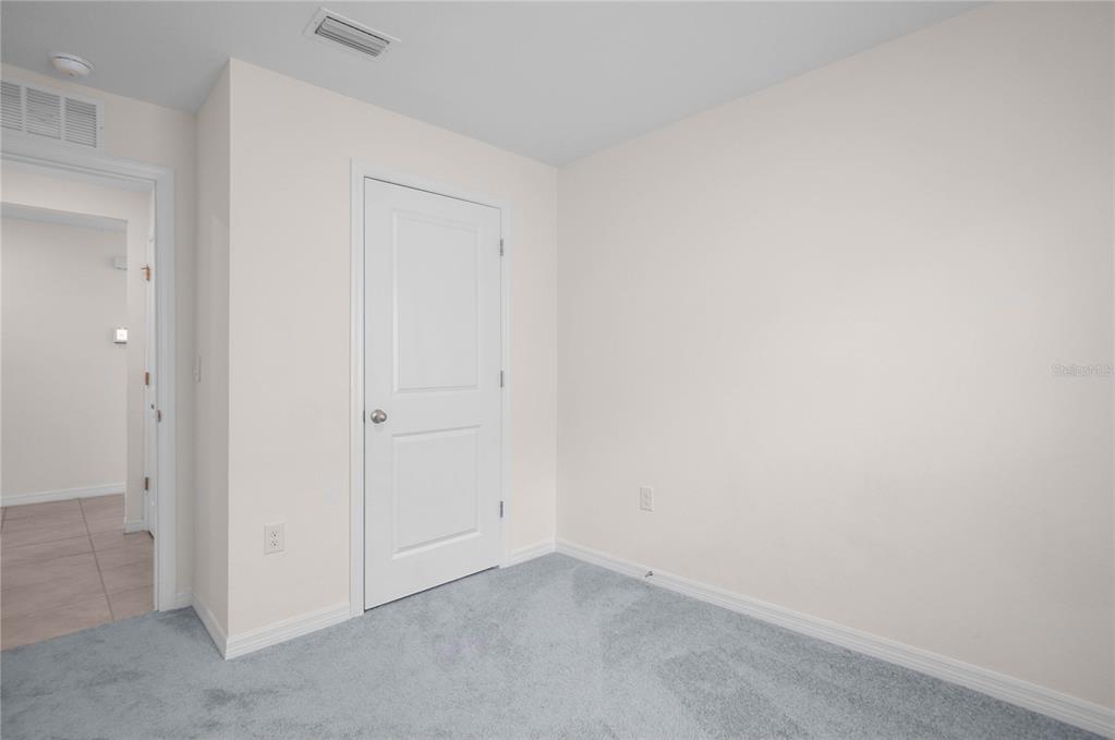 8471 Clearway Drive Wildwood, FL 34785 - Photo 19 of 32 an empty room with a hallway