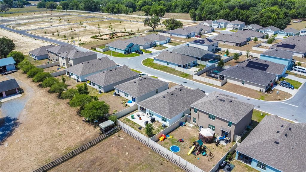 8471 Clearway Drive Wildwood, FL 34785 - Photo 28 of 32 an aerial view of multiple houses with yard