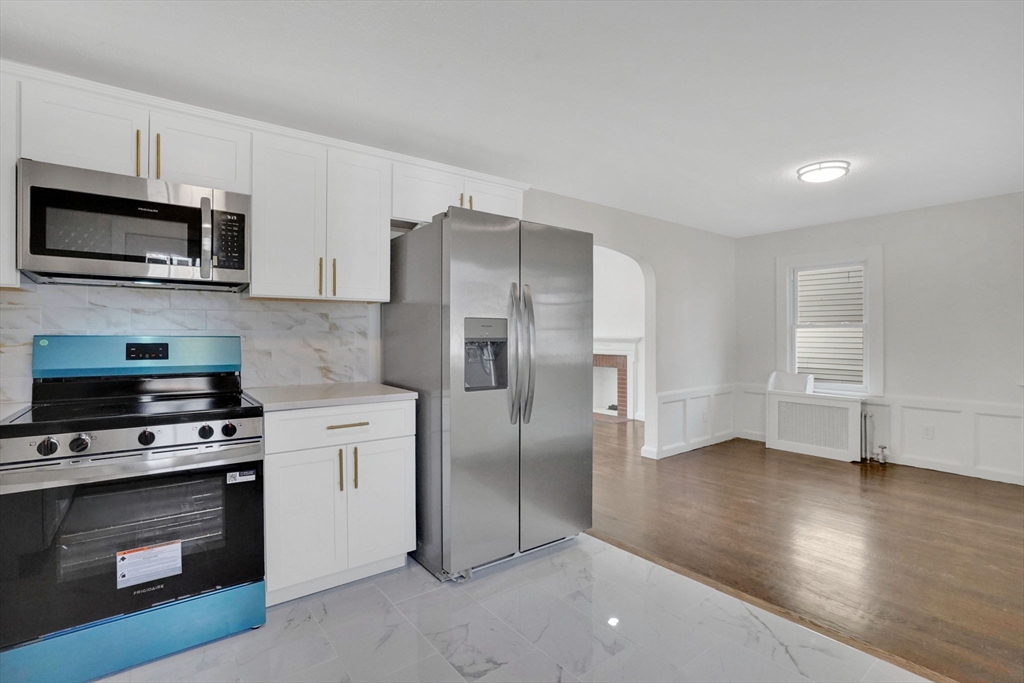 100 Abbott Street Springfield, MA 01118 - Photo 18 of 31 a kitchen with stainless steel appliances a stove a microwave and a hard wood floors