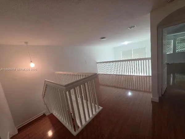 a view of empty room with wooden floor