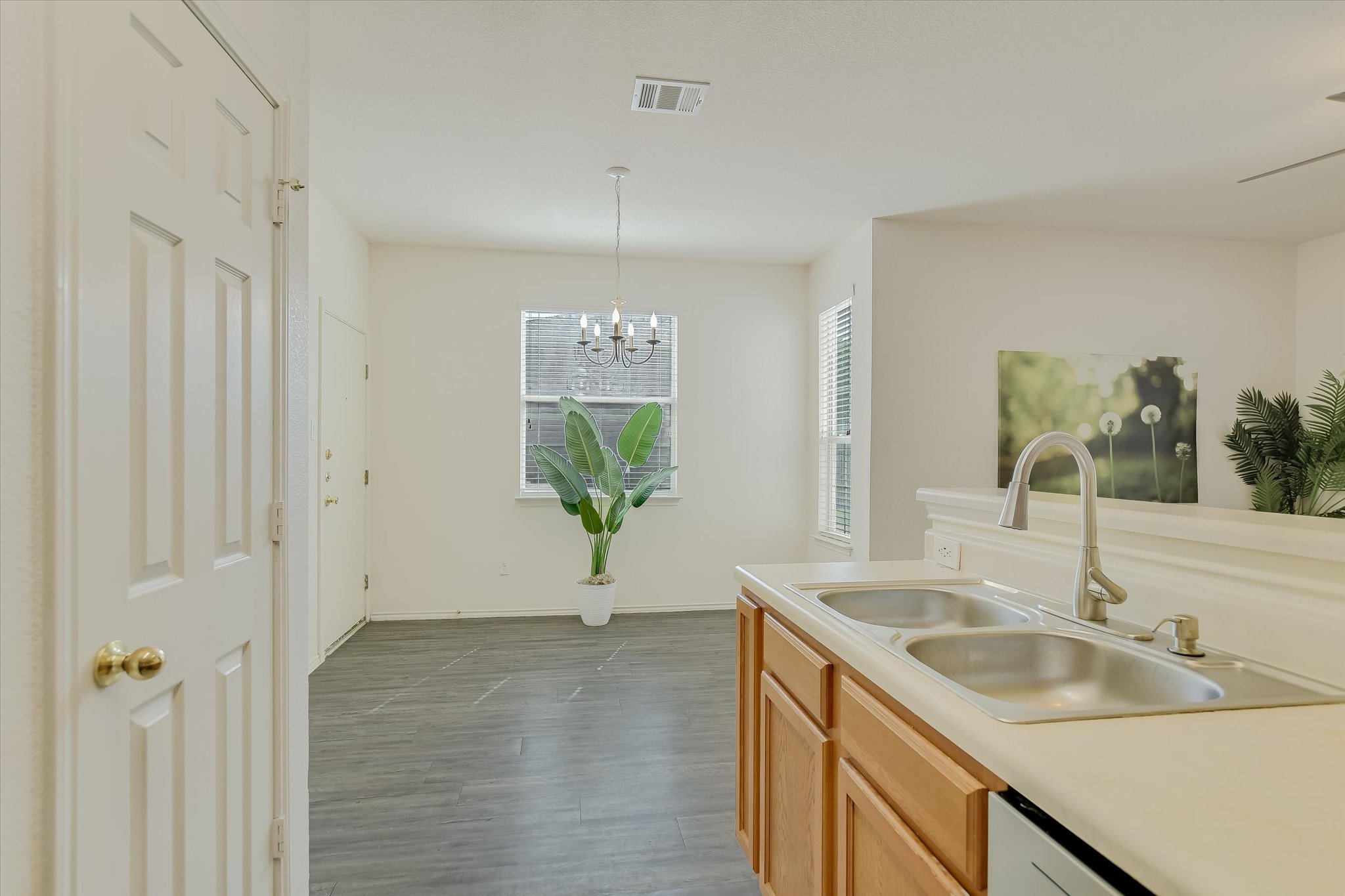 809 Sebastian Bend, Unit B Pflugerville, TX 78660 - Photo 11 of 34 Kitchen featuring light countertops, dark wood finished floors, light wood finish cabinets, and suspended lighting