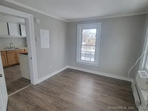 a view of a kitchen with wooden floor and a window