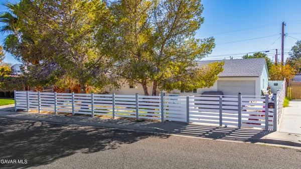 a view of street with wooden fence