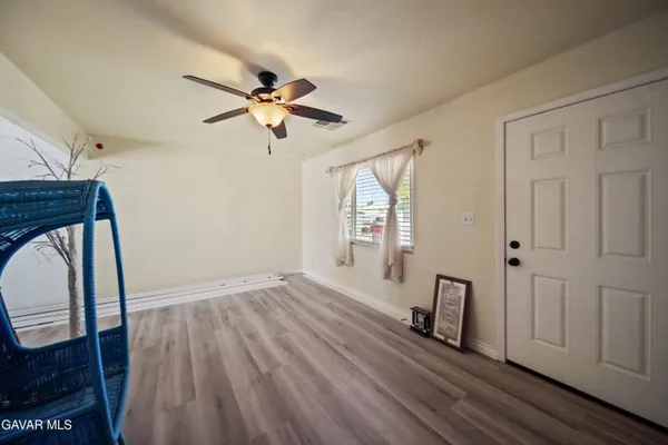 a view of a livingroom with wooden floor and a ceiling fan