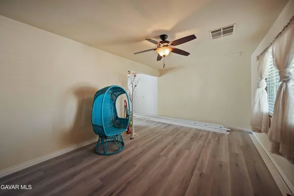 a view of a room with wooden floor and a ceiling fan