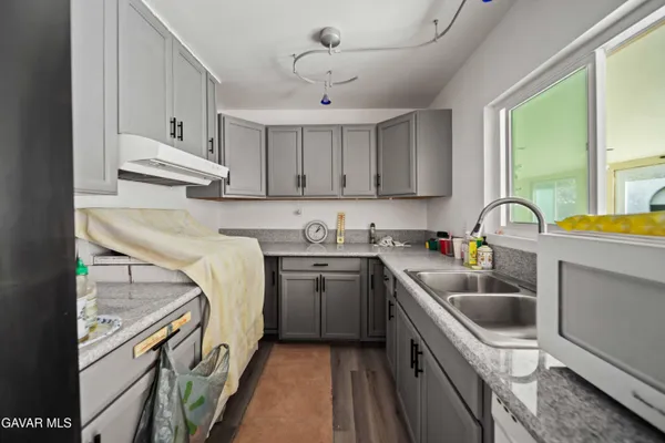 a kitchen with a sink a stove and cabinets