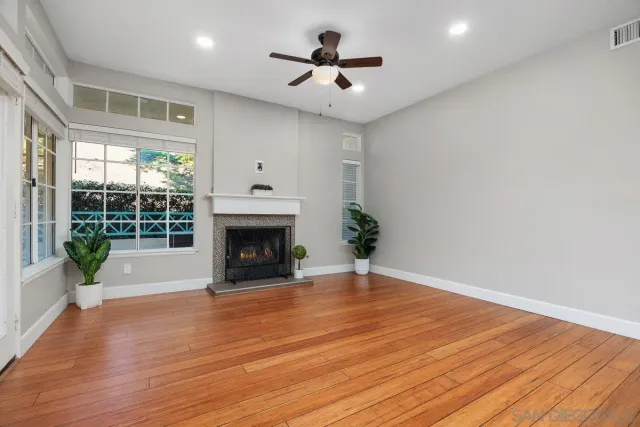 a view of empty room with wooden floor and a fireplace