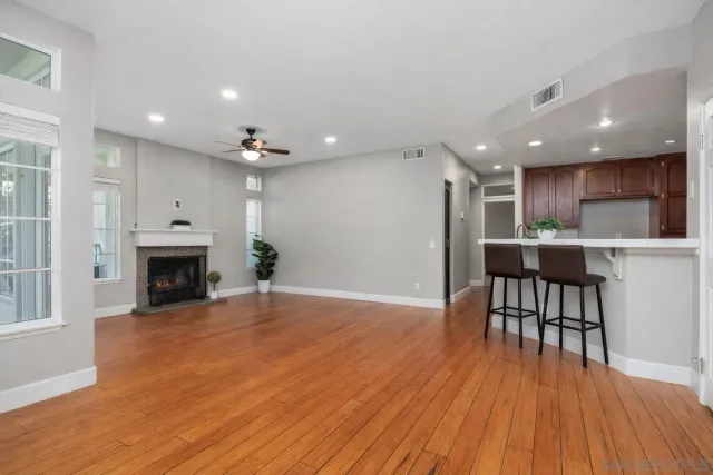 a view of a kitchen and dining room with wooden floor a fireplace