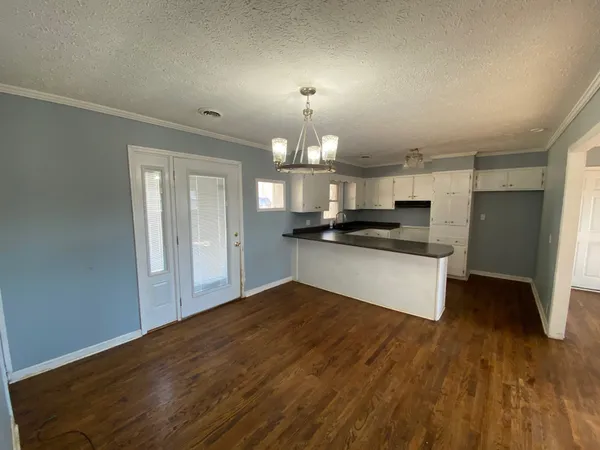 a view of kitchen with granite countertop cabinets and refrigerator