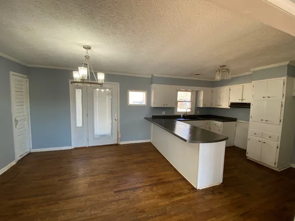 a view of kitchen with granite countertop refrigerator and sink