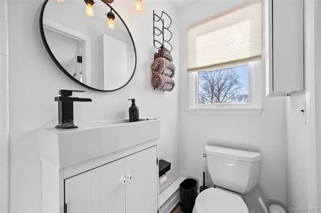 a bathroom with a toilet a sink and a mirror