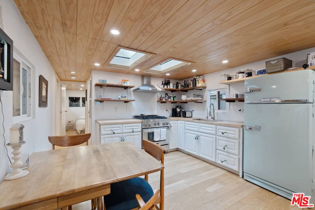 68 Paradise Cove Road Malibu, CA 90265 - Photo 3 of 28 a kitchen with white cabinets stainless steel appliances and sink