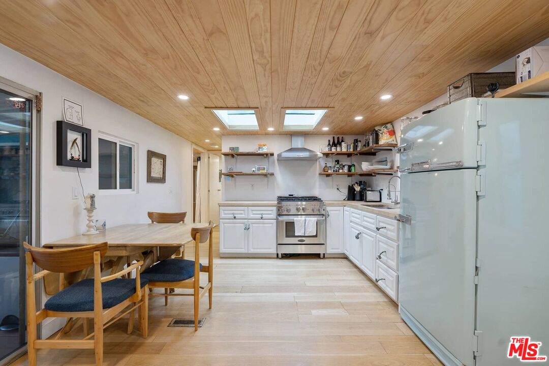 68 Paradise Cove Road Malibu, CA 90265 - Photo 4 of 28 a kitchen with white cabinets and chairs
