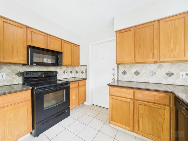 a kitchen with granite countertop cabinets stainless steel appliances and a sink