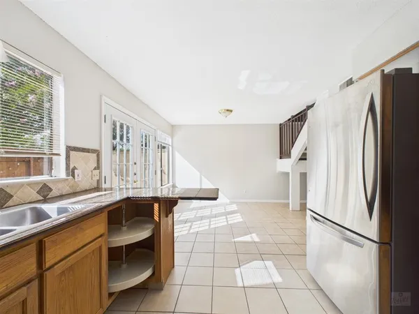 a kitchen with a sink a refrigerator and cabinets