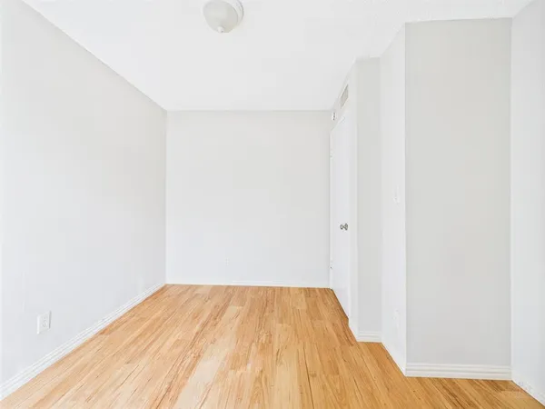 a view of a room with wooden floor and a window