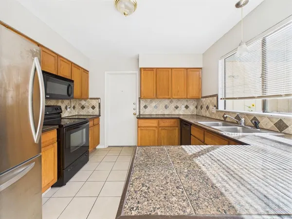 a kitchen with stainless steel appliances granite countertop a sink and a stove