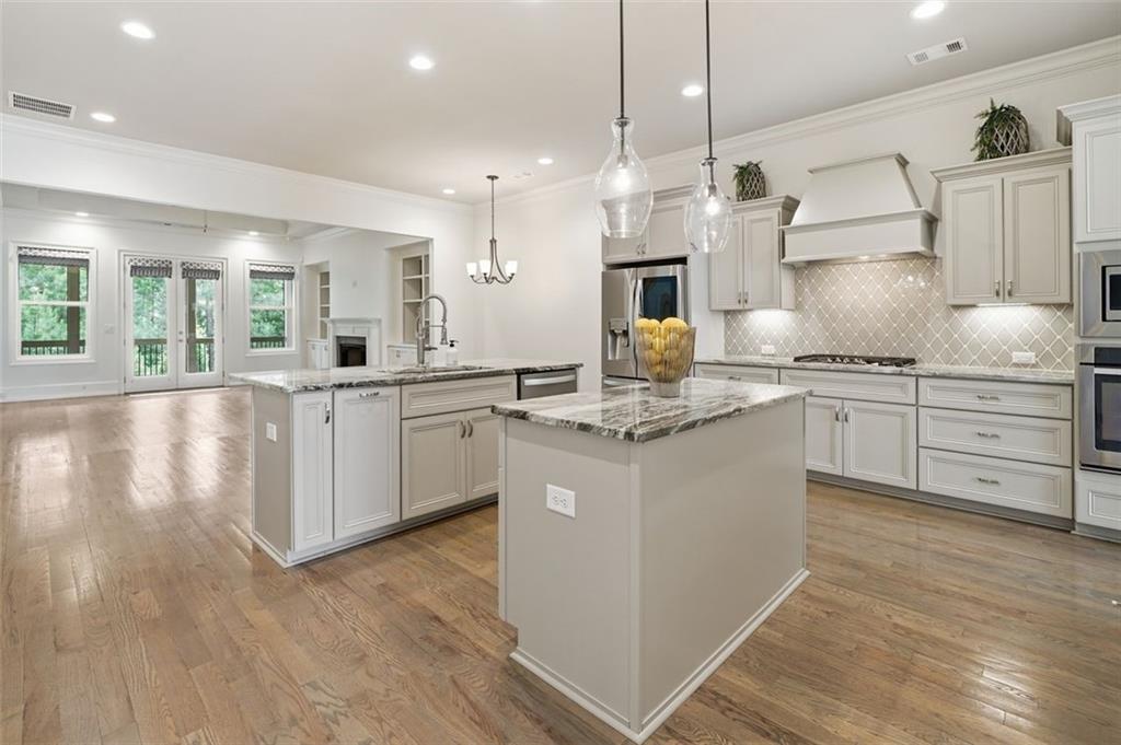 337 Rosshandler Road Suwanee, GA 30024 - Photo 10 of 45 a kitchen with kitchen island granite countertop a sink a counter space appliances and cabinets