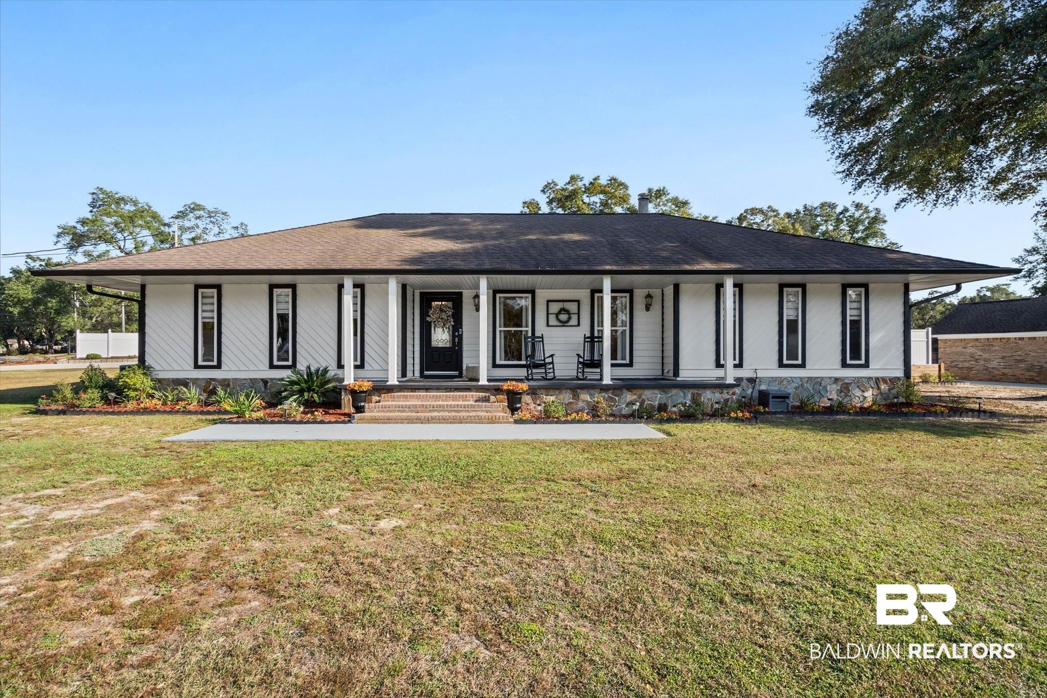 4567 Pine Avenue Saraland, AL 36571 - Photo 1 of 48 Ranch-style house featuring covered porch, a front lawn, and roof with shingles