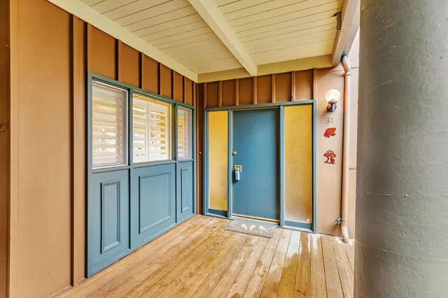 a view of a hallway with wooden floor and entryway