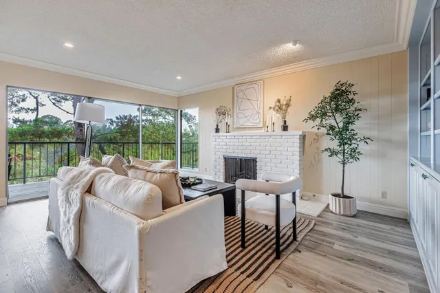 a living room with furniture large window and fireplace