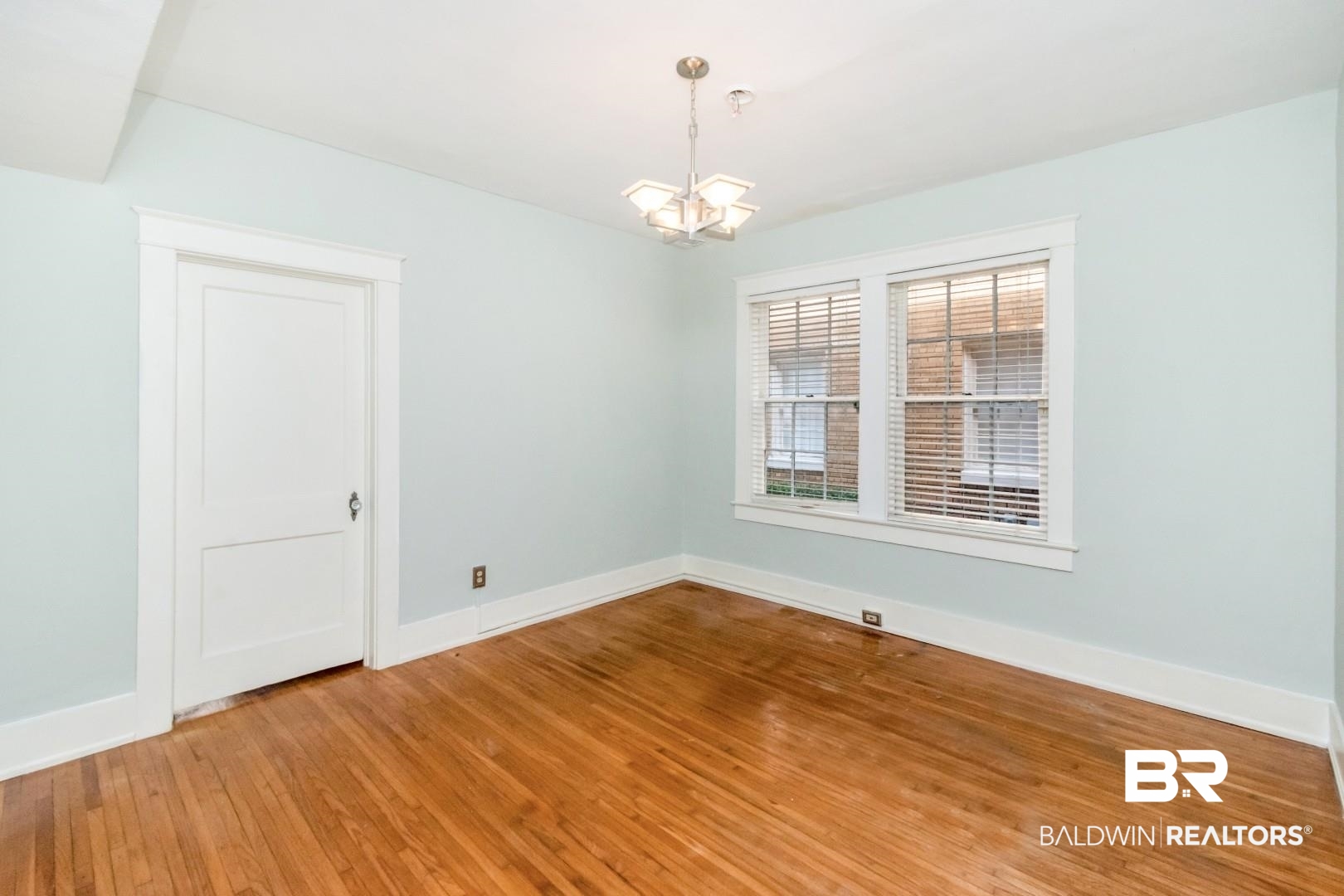 1602 Government Street, Unit 1A Mobile, AL 36604 - Photo 12 of 24 Empty room with light wood-style floors and a chandelier