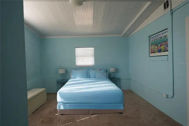 a bedroom with a bed and a painting on the wall