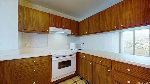 a kitchen with stainless steel appliances granite countertop wooden cabinets a stove and a window