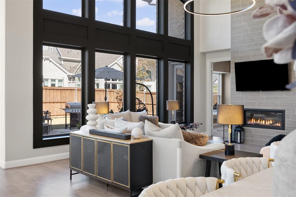 2413 Shane Drive Midlothian, TX 76065 - Photo 11 of 37 a living room with furniture a flat screen tv and a floor to ceiling window