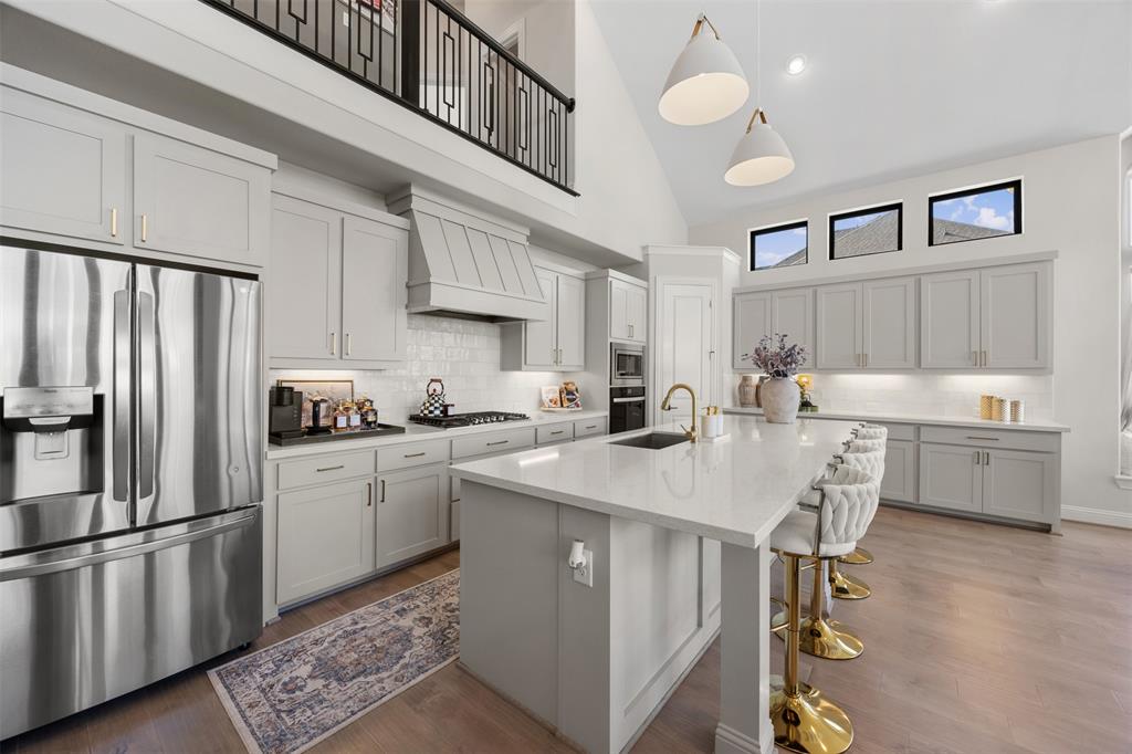 2413 Shane Drive Midlothian, TX 76065 - Photo 20 of 37 a kitchen with stainless steel appliances a stove a sink dishwasher a refrigerator and white cabinets with wooden floor