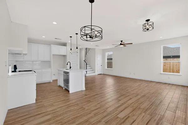 a kitchen with stainless steel appliances granite countertop a sink a stove and a wooden floors