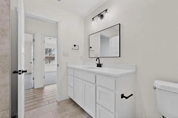 a bathroom with a toilet sink and mirror