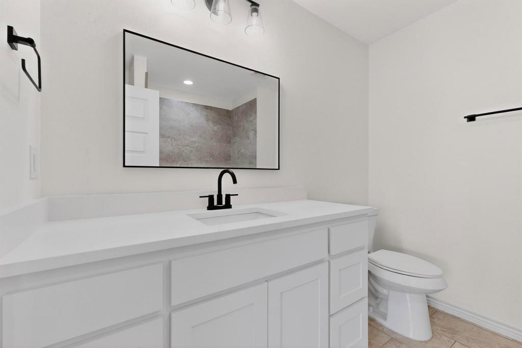 1610 Life Avenue Dallas, TX 75212 - Photo 17 of 38 a bathroom with a toilet sink and mirror