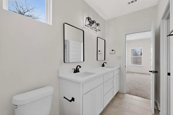 a bathroom with a sink a toilet and a mirror