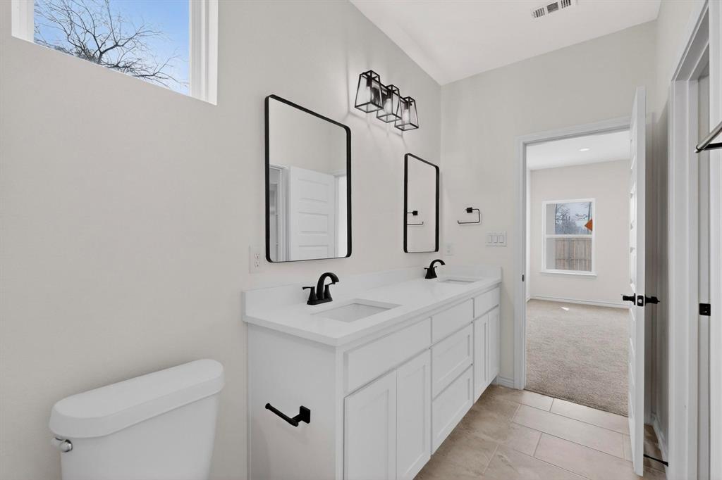 1610 Life Avenue Dallas, TX 75212 - Photo 22 of 38 a bathroom with a toilet sink and mirror