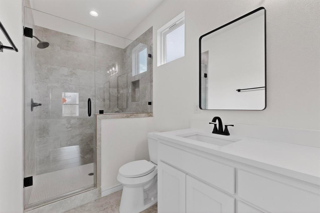 1610 Life Avenue Dallas, TX 75212 - Photo 24 of 38 a bathroom with a sink a toilet and a mirror