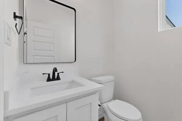 a bathroom with a toilet sink and mirror
