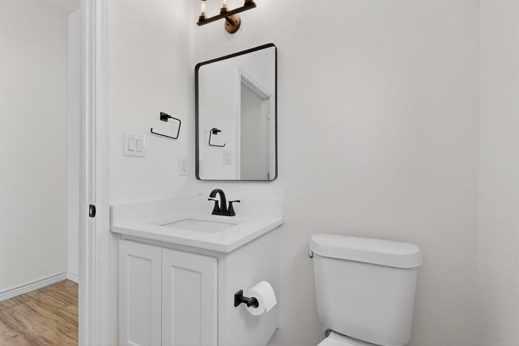 1610 Life Avenue Dallas, TX 75212 - Photo 32 of 38 a bathroom with a toilet sink and mirror