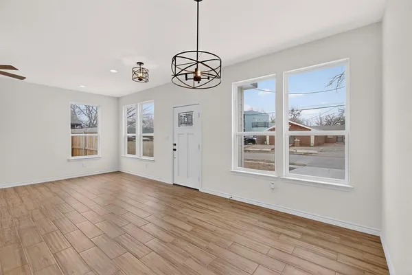 a view of empty room with wooden floor and ceiling fan