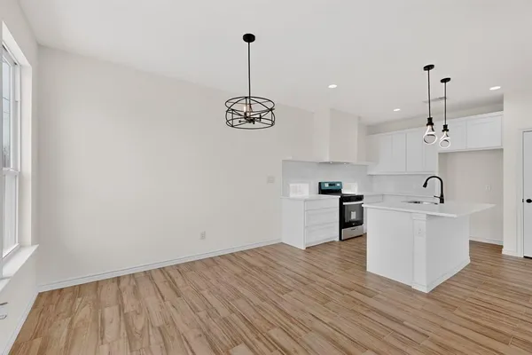 a view of a kitchen with stove and wooden floor