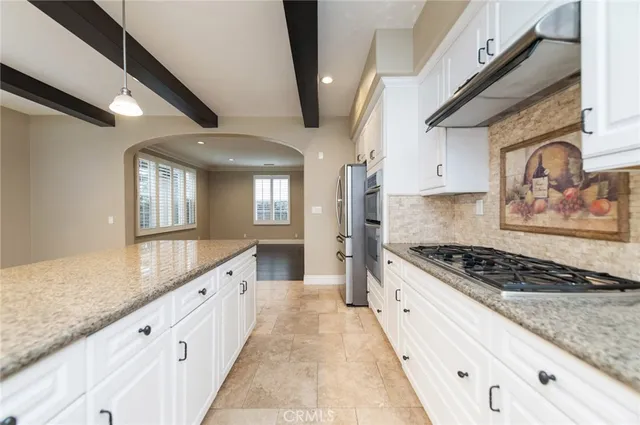 a large kitchen with stainless steel appliances granite countertop a stove and a sink