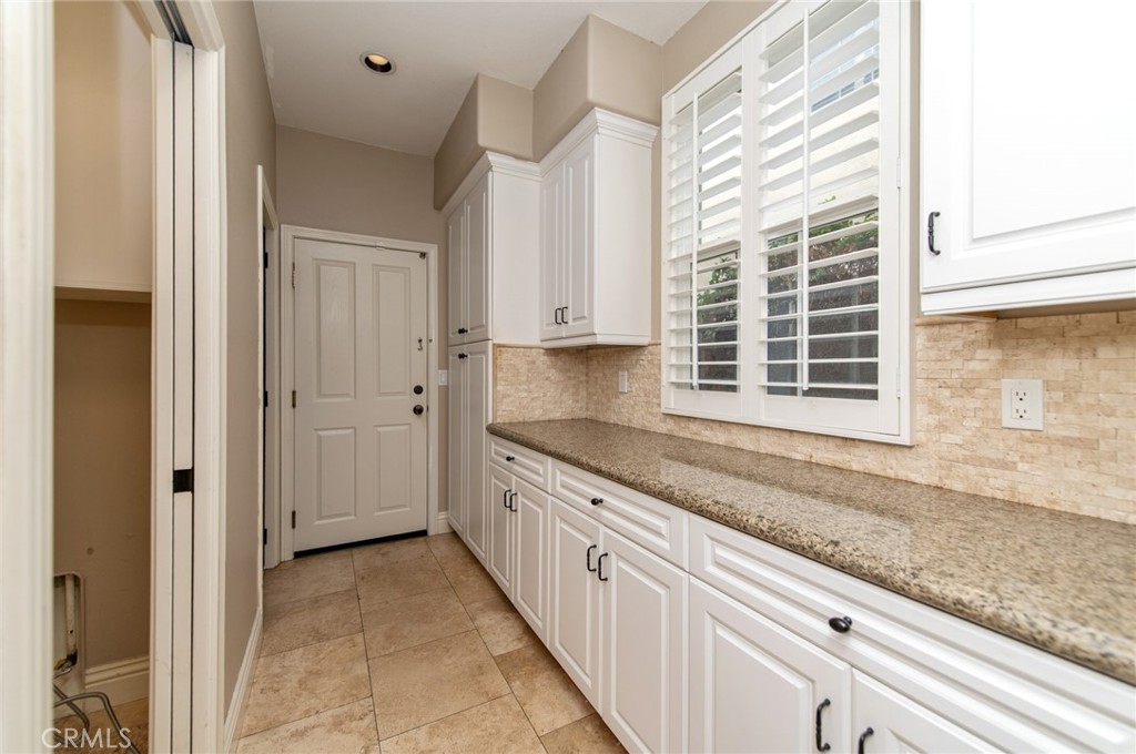 26 Secret Garden Irvine, CA 92620 - Photo 14 of 38 a kitchen with granite countertop white cabinets and a window