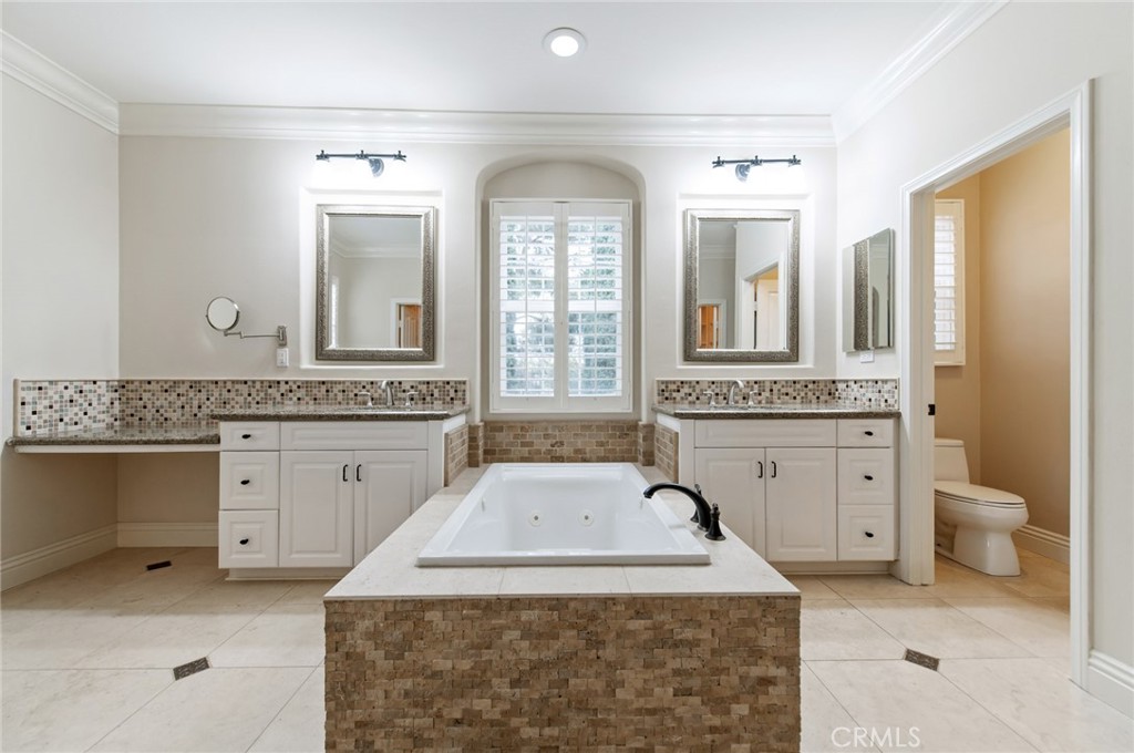 26 Secret Garden Irvine, CA 92620 - Photo 18 of 38 a spacious bathroom with a granite countertop sink and a mirror