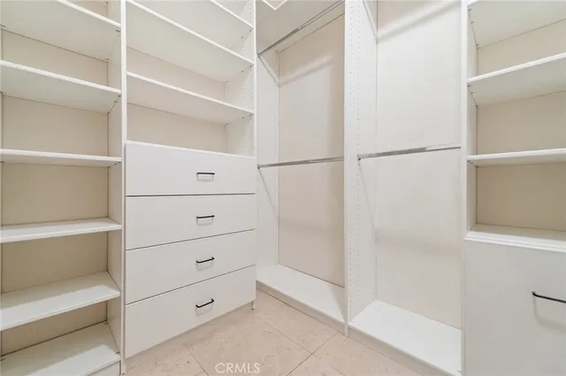 a view of walk in closet with empty racks