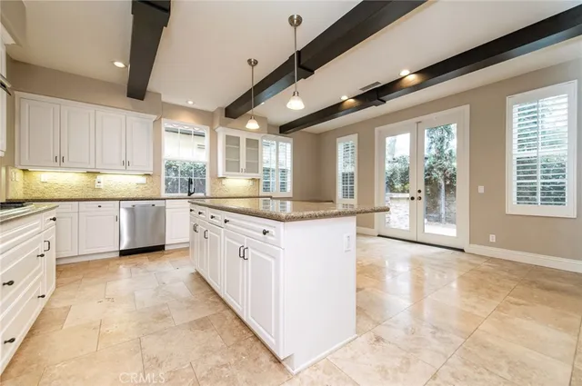a large kitchen with kitchen island a large counter top space a sink stainless steel appliances and cabinets