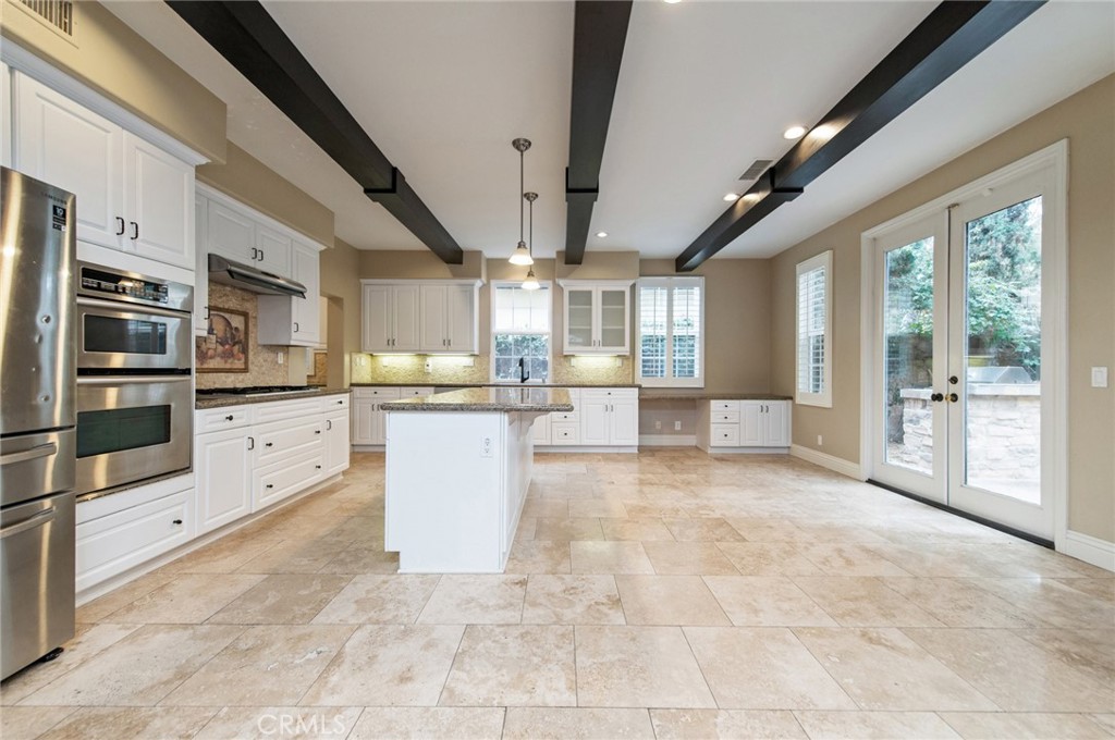 26 Secret Garden Irvine, CA 92620 - Photo 10 of 38 a large white kitchen with granite countertop a large window and stainless steel appliances