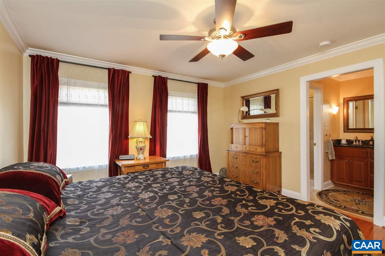 52 Oak Grove Road Palmyra, VA 22963 - Photo 17 of 46 a bedroom with a large bed and a chandelier