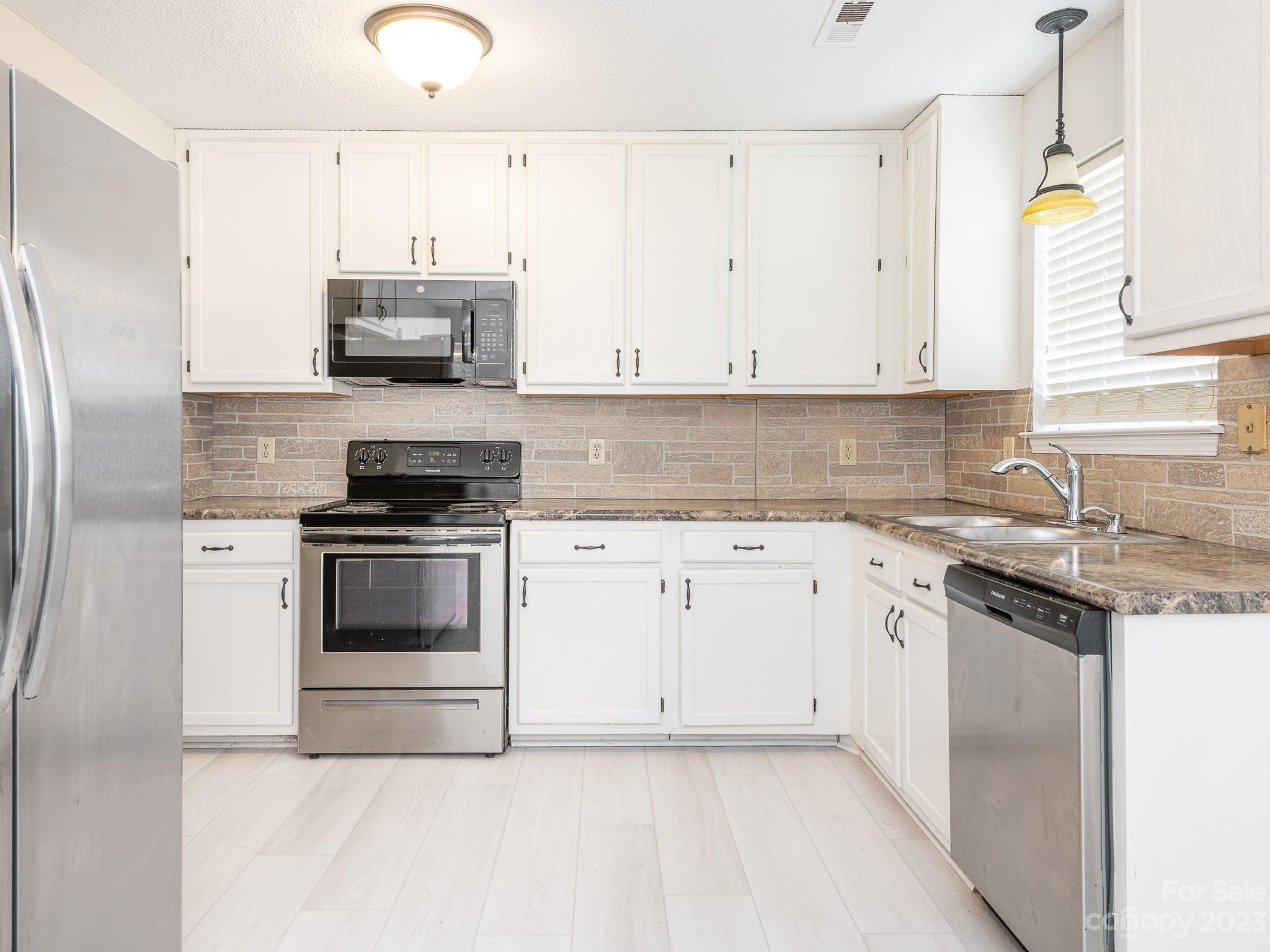 1007 Ridgefield Circle Indian Trail, NC 28079 - Photo 12 of 35 a kitchen with stainless steel appliances white cabinets and a sink
