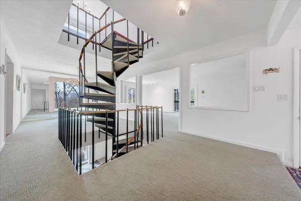 a view of an empty room with chandelier fan
