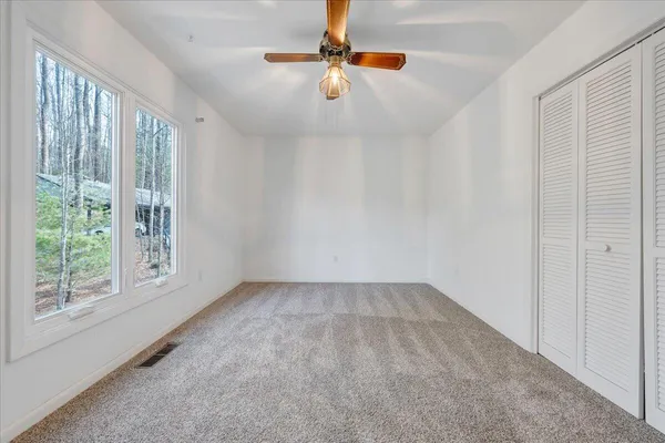 a view of an empty room with stairs and a window